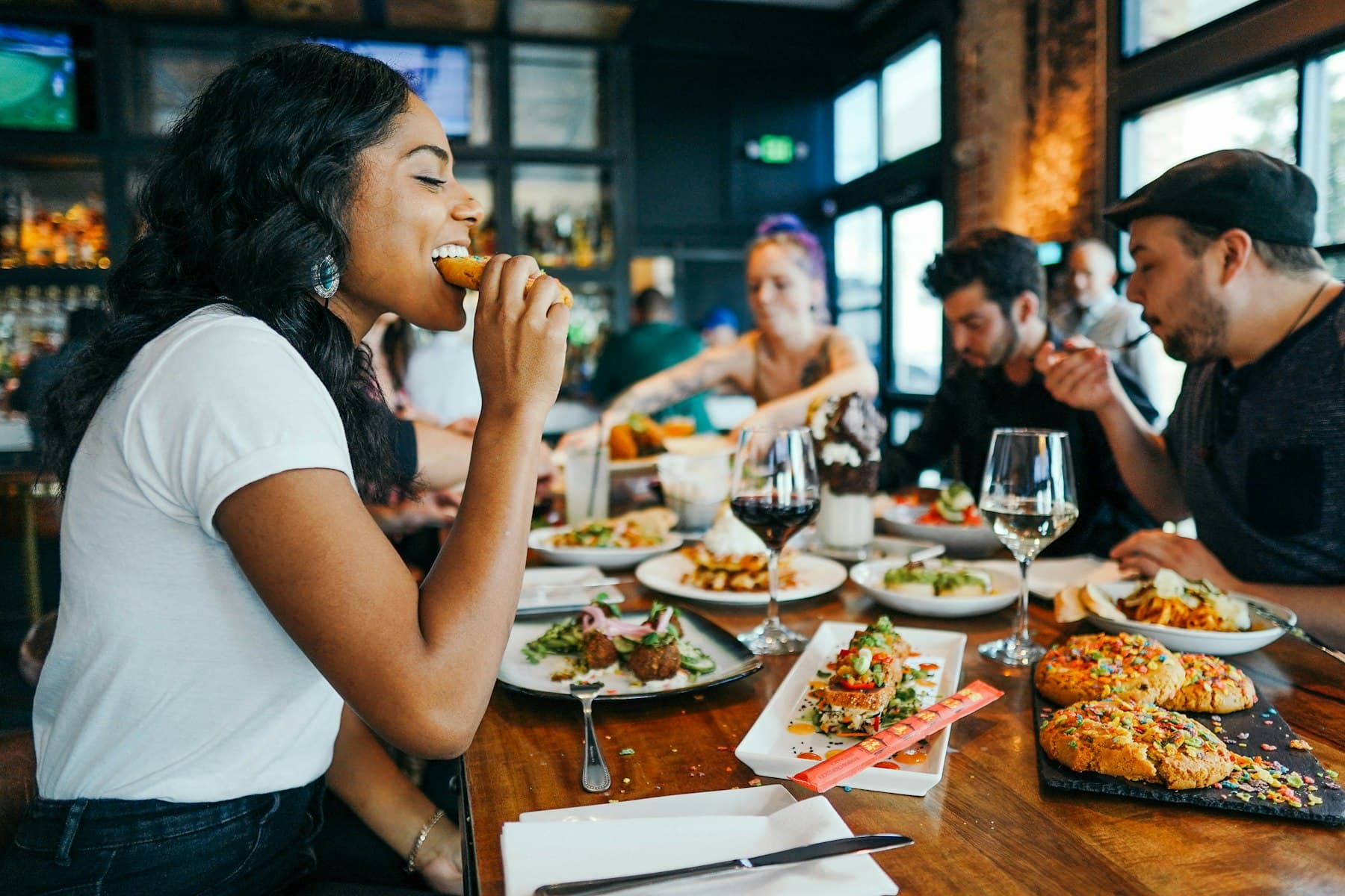 Friends sharing dishes at a busy restaurant table